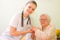 a nurse holding an old woman's hand